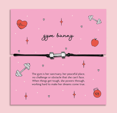 Adjustable black cord Gym Bunny bracelet with silver dumbbell charm displayed on pink motivational fitness message card, workout and gym gift for her.