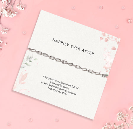 a wedding gift wishing a 'happily ever after', a heartfelt poem card and silver-plated and cubic zirconia bracelet gift with white flowers scattered round