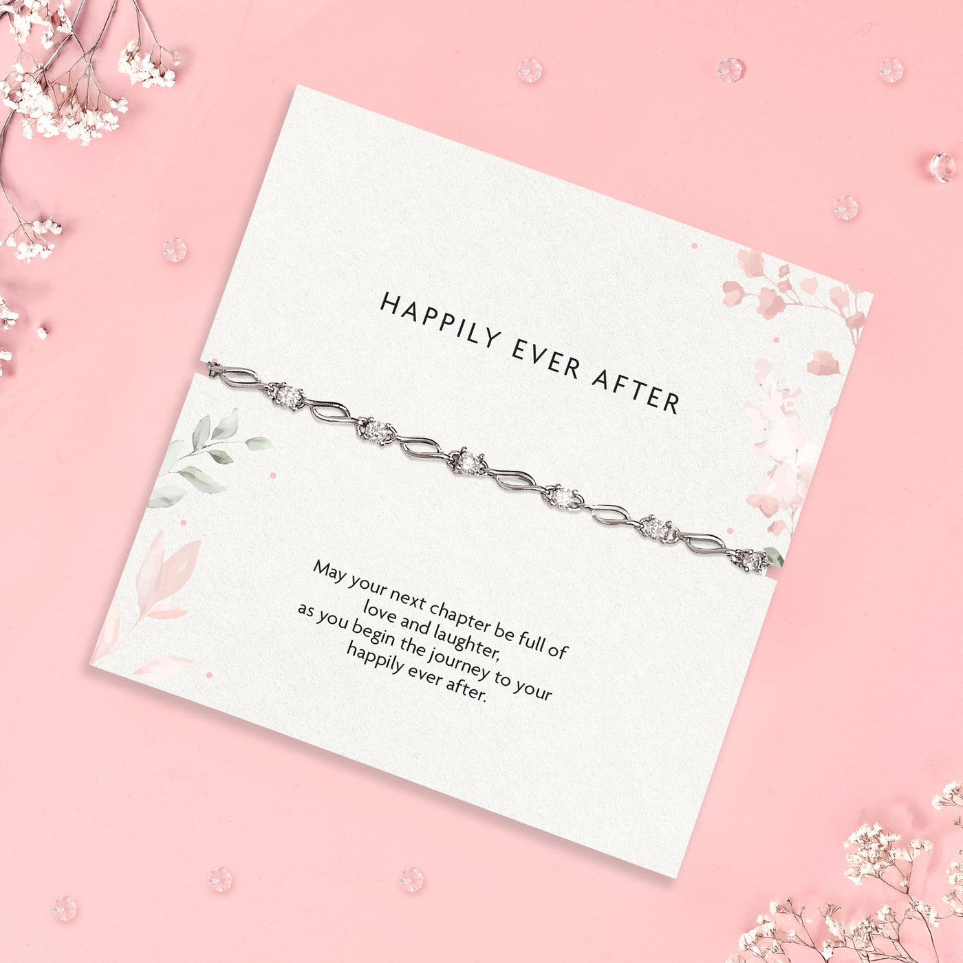 a wedding gift wishing a 'happily ever after', a heartfelt poem card and silver-plated and cubic zirconia bracelet gift with white flowers scattered round