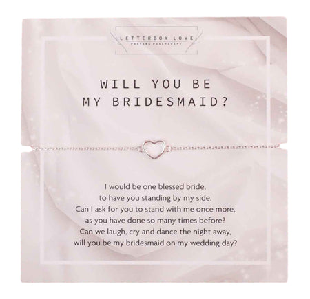 An elegant bridesmaid proposal bracelet with a small heart-shaped charm, displayed on a white card with the message 'WILL YOU BE MY BRIDESMAID?' in bold letters. The card contains a touching poem asking a friend to stand by the bride's side on her wedding day, set against a translucent white overlay with a faint floral pattern in the background.