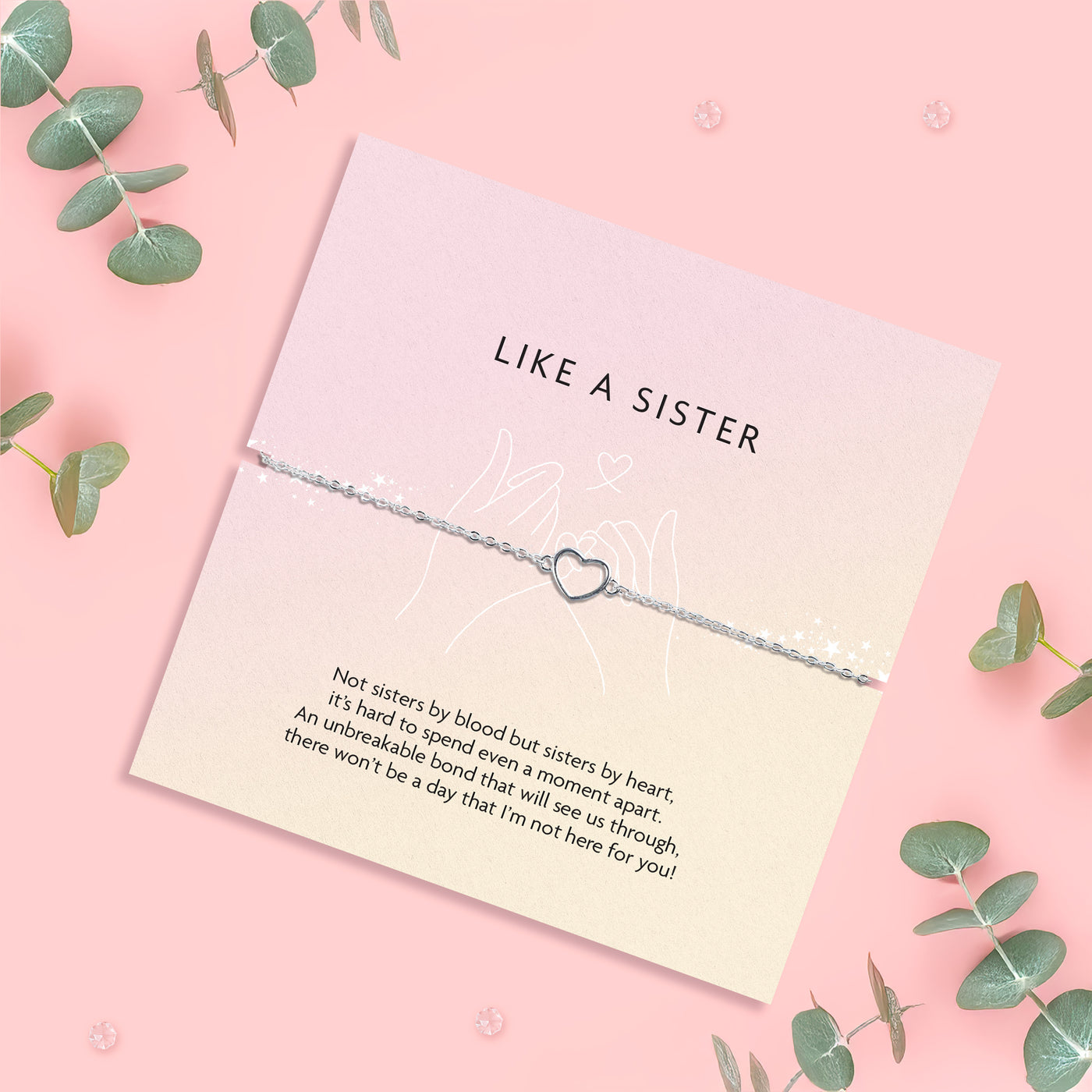 a pink background with a like a sister poem card and silver-plated hollow heart bracelet surrounded by eucalyptus