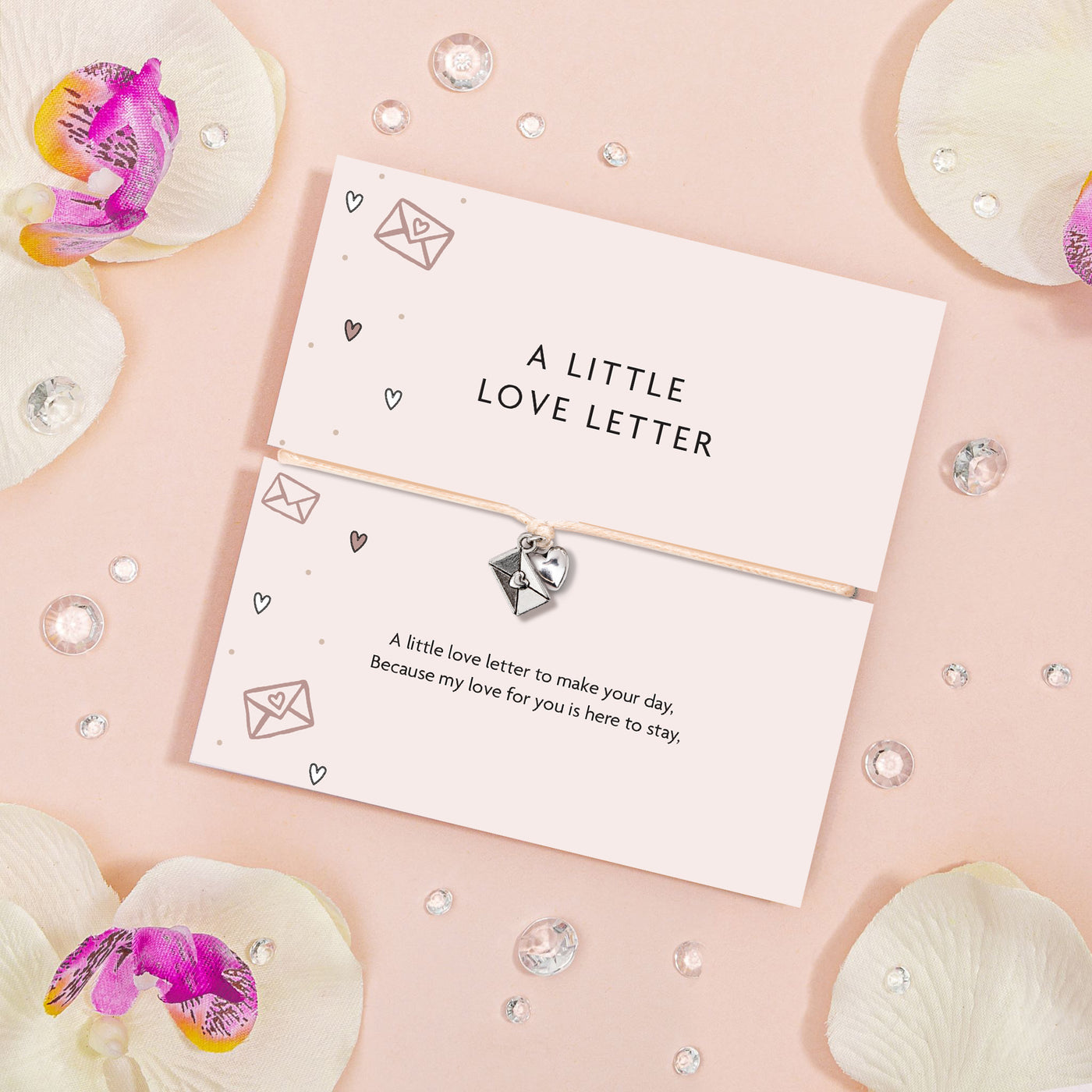 Card with 'A Little Love Letter' text on a pink background with decorative elements. The bracelet is a cute charm bracelet to say 'love you'