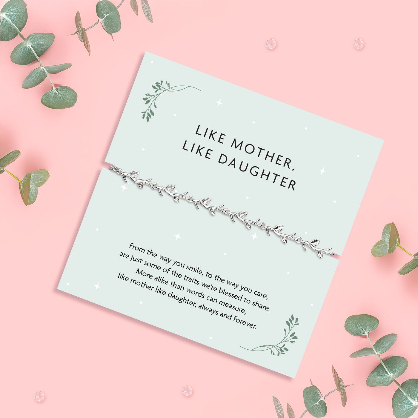 a pale pink background with eucalyptus stems with a sage green poem card with 'like mother like daughter' poem. A silver-plated vine bracelet makes a beautiful gift for a daughter.
