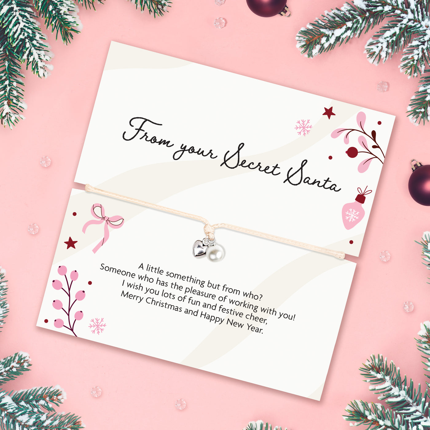 A beautiful Secret Santa gift that reads 'From your Secret Santa' with a joyful poem. With a delicate pearl and heart bracelet. This is the perfect secret Santa gift for under £10 with christmas branches and baubles surrounding the card.