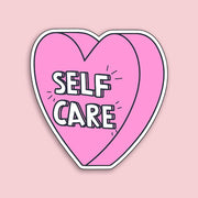 Heart-shaped sticker with 'SELF CARE' text on a pink background