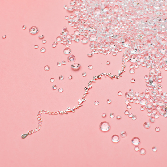 A pink background with silver-plated bracelet and scattered gems. A beautiful gift for a sister-in-law