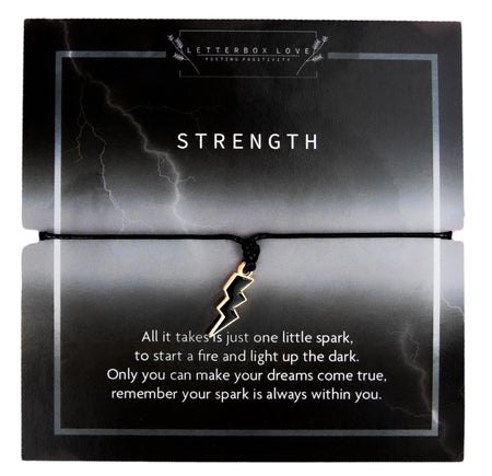 Bracelet card featuring a bold lightning bolt charm on a black string, set against a dark background with lightning imagery. The card reads 'Strength' and includes an empowering message about finding your inner spark to light up the dark and achieve your dreams. The lightning bolt symbolizes power and resilience, making this a perfect gift for motivation and encouragement.