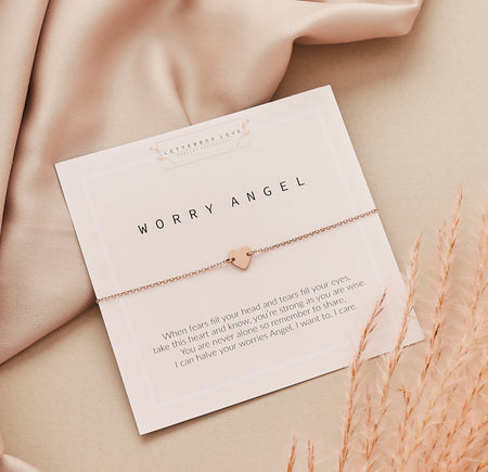 A Worry Angel bracelet with a heart charm on a rose gold or gold-coloured stainless steel chain, paired with a comforting message offering support and love for those going through challenging times.