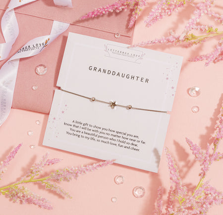 A delicate bracelet gift for a granddaughter, presented on a 'Letterbox Love' card with a touching poem. The bracelet features a central star charm flanked by two small beads on a silver chain, symbolizing love and guidance. The card and bracelet are designed with a subtle pink starry background, conveying affection and tenderness.
