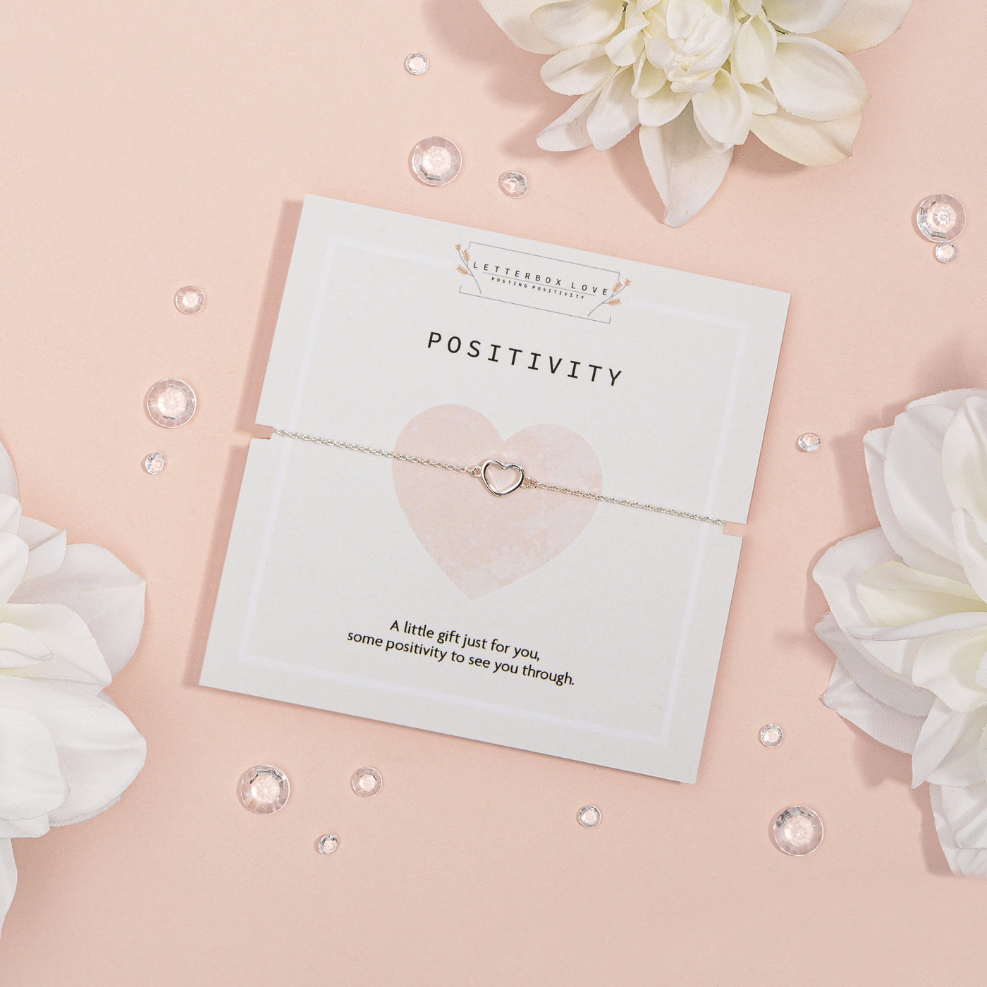 Elegant silver heart-shaped necklace on a 'POSITIVITY' card with the message 'A little gift just for you, some positivity to see you through.