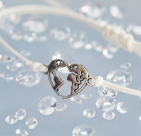 A blue background with scattered gems, the bracelet is white and adjustable with a silver globe charm in the centre. A travel gift.